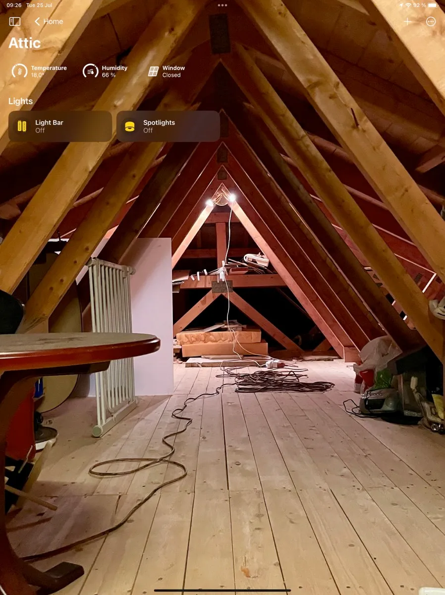 Home-appen for loftet: temperatur 18,0°, luftfuktighet 66 %, vindu lukket, og lysene «Light Bar» og «Spotlights», begge av