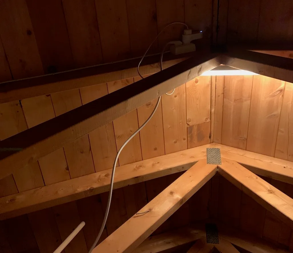 LED-lysrør som lyser opp mønet, med den lange hvite ledningen langs sperrene