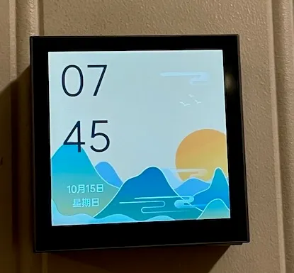 Smart veggbryter som styrer takviften og -lampen og de andre enhetene i rommet. Til venstre vises den i skjermsparemodus (den blir helt svart etter 30 sekunder) og til høyre med de definerte “knappene”